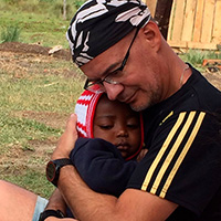 Vicente Enguita abrazando a un niño de Agua ONG